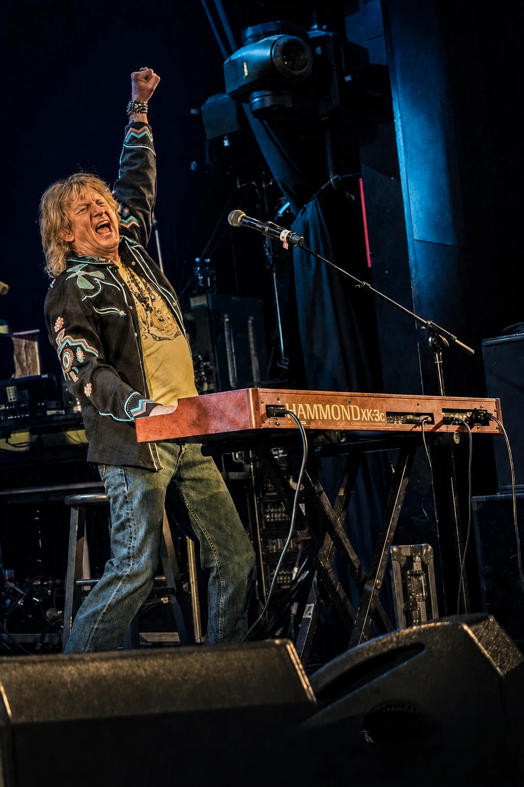 Eddie Stone performing live with his Hammond XK-3c keyboard, fist raised triumphantly on stage